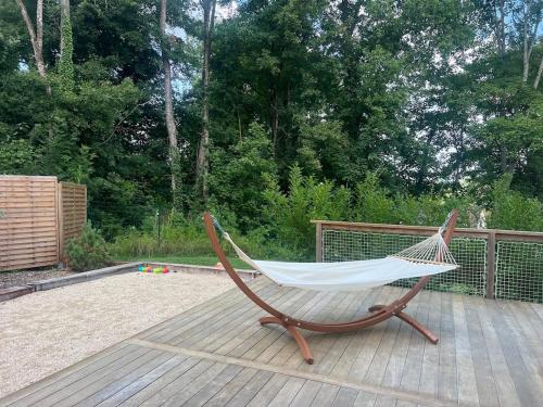 a hammock sitting on top of a wooden deck at Villa Marine, Jacuzzi, 25' Disneyland in La Celle-sur-Morin