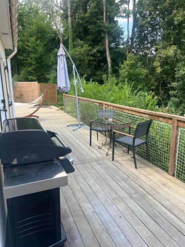 a deck with a table and a grill and a table and chairs at Villa Marine, Jacuzzi, 25' Disneyland in La Celle-sur-Morin