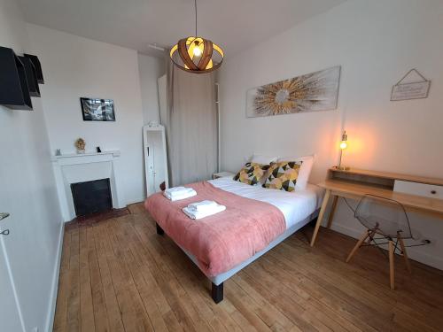 a bedroom with a bed and a desk in it at Le 84bis, maison, proche gare, parking, Netflix in Laval