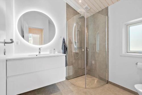 a bathroom with a shower and a sink and a mirror at 0122-Romo-Smafolksvej-44 in Høm
