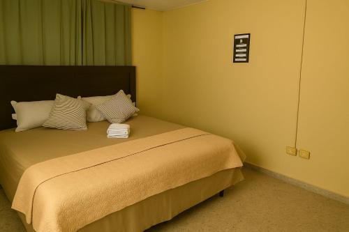 a bedroom with a bed with two towels on it at Go Bed & Breakfast in San Pedro Sula