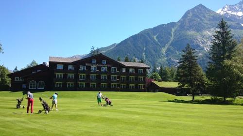a group of people playing golf in front of a building at Hôtel Le Labrador in Chamonix-Mont-Blanc