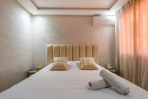a bedroom with a large white bed with two pillows at Marrakech Duplex Spacieux avec Terrasse in Marrakech
