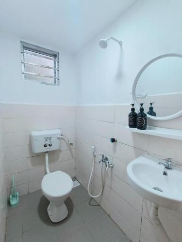 Un baño blanco con inodoro y lavabo. en Adriana RH Homestay 3Bedroom 2Bathroom, en Kampong Bukit Rambai