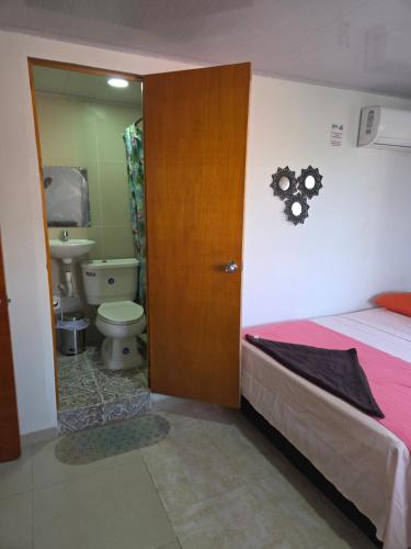 a bedroom with a bed and a bathroom with a toilet at P.N Manchineel road Providence Island ECORELAX in Providencia