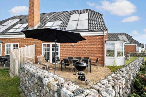 a grill with an umbrella in front of a house at 0332-Romo-Sonder-Frankel-38 in Havneby