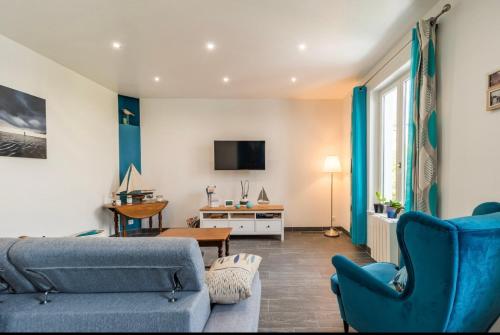 un soggiorno con un divano blu e una TV di ker corre a Étables