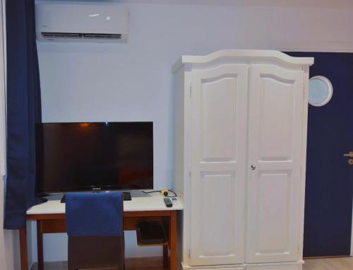 a room with a desk and a tv and a white door at Brise Marine in Le Marin