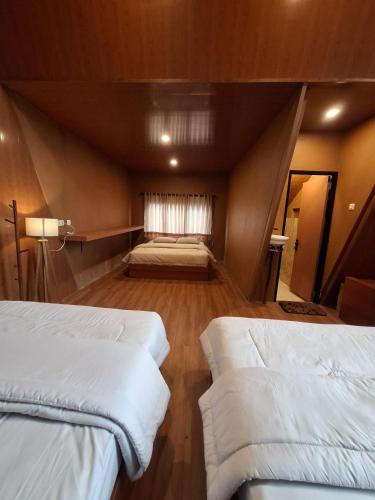 a room with two beds and a window in it at Dieng Latar Alam Tambi Syariah in Kejajar