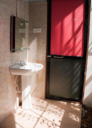 a bathroom with a sink and a mirror at Coco Breeze Cabanas - free Airport pick up or drop off in Katunayake