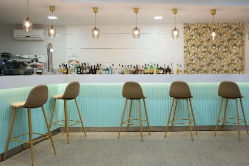 a row of stools in front of a bar at Hotel Maya Alicante in Alicante