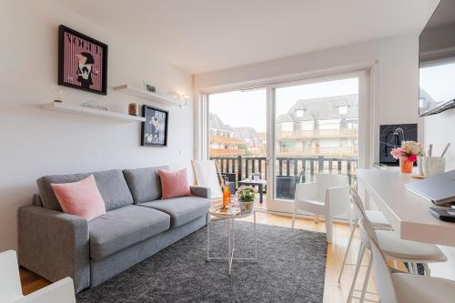 a living room with a couch and a table at Le 112 Deauville - Plage & Casino in Deauville