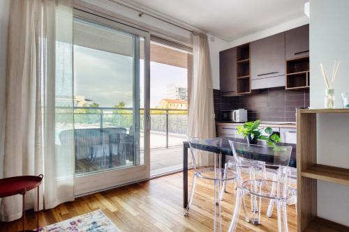 a kitchen with a glass table and a balcony at GiaxTower Gym Spa & Pool Romantic Pool View in Milan