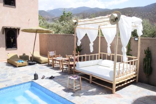 a bed and a canopy next to a pool at Wild Valley Ouirgane in Ouirgane