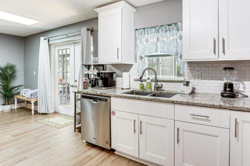 a kitchen with white cabinets and a sink at Palm Coast Escape with Outdoor Oasis 6 Mi to Shore! in Palm Coast