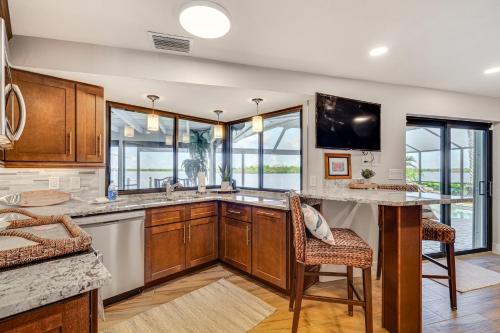 a kitchen with a large counter and some windows at Water Views and Dock Tranquil Matlacha Island Home in Matlacha
