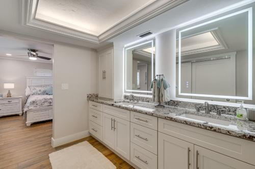 a bathroom with two sinks and two mirrors at Water Views and Dock Tranquil Matlacha Island Home in Matlacha