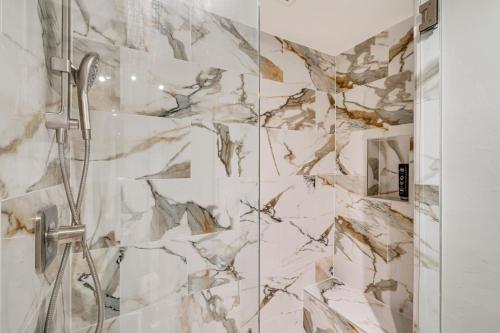 a shower in a bathroom with a marble wall at Water Views and Dock Tranquil Matlacha Island Home in Matlacha