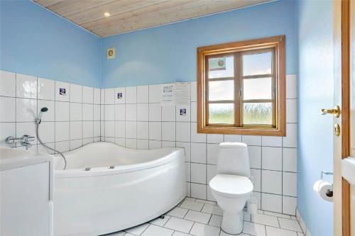 a bathroom with a tub and a toilet and a sink at 0126-Romo-Lakolk-201 in Lakolk