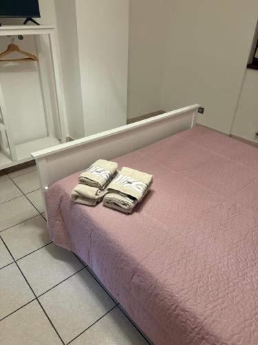 a pink bed with two towels on top of it at Civico 16 in Asso