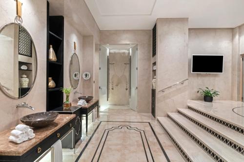 a bathroom with a tub and a sink and a mirror at Rixos Marina Abu Dhabi in Abu Dhabi