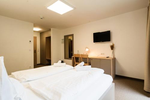Un dormitorio con dos camas y un televisor en la pared. en Hotel Stubnerhof, en Bad Gastein