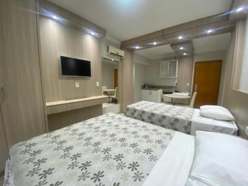 a hotel room with two beds and a television at IMG Hotel Rio Quente in Rio Quente