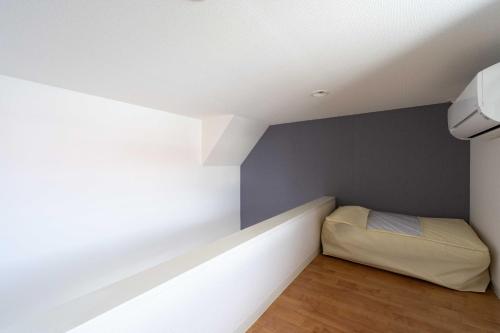 a small room with a bed in the corner at FukuokaKukouGoodStay in Fukuoka