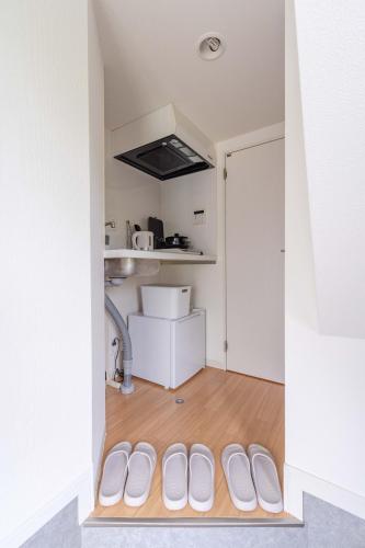 a room with a door with white shoes in it at FukuokaKukouGoodStay in Fukuoka