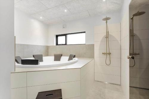 a bathroom with a bath tub and a shower at 8902-Allingabro-Dalgardsvej-4 in Allingåbro