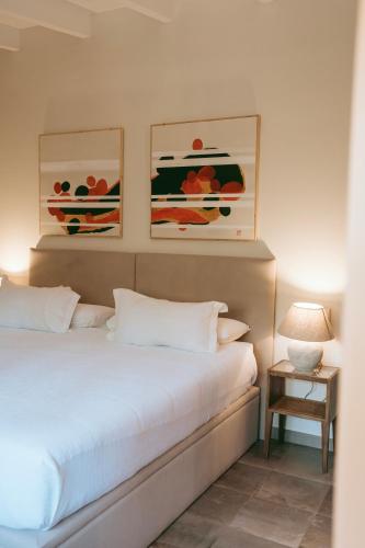 a bedroom with a bed with two pictures on the wall at Rondaia, a Winery & Fincahotel-Agroturismo in Tramuntana in Esporles