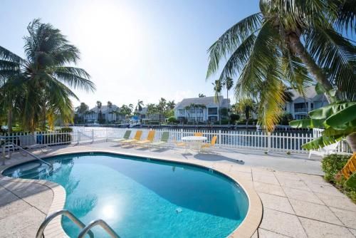 a swimming pool with palm trees and a resort at Snug Harbour View Condo #8 in George Town