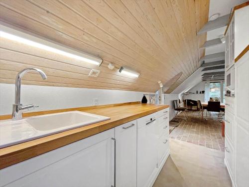 a kitchen with a sink and a wooden ceiling at 0209-Romo-Vrabyvej-34 in Vesterhede