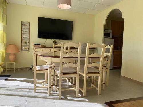 a dining room with a table and chairs and a television at Appartement confortable à Aigues-Mortes de 60 m² in Aigues-Mortes