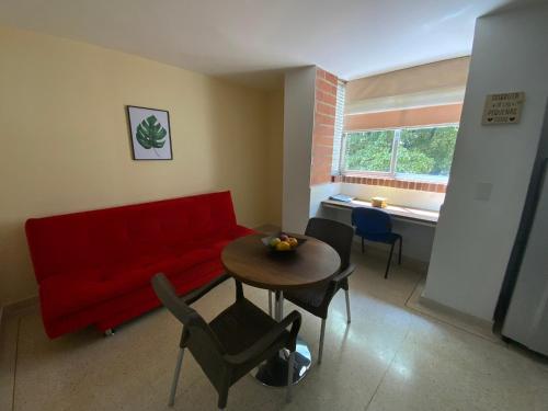 a living room with a red couch and a table at Amoblados Medellín Laureles in Medellín
