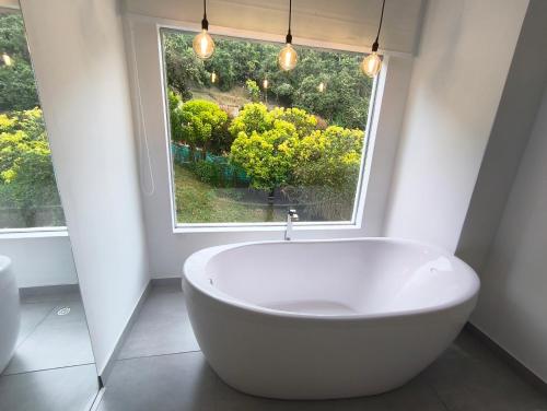 a bath tub in a bathroom with a window at Mirador samsara Suite Luxury Tina vista a la montaña in La Calera