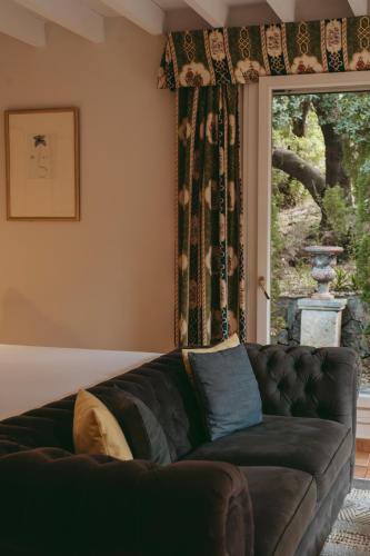 a living room with a couch in front of a window at Rondaia, a Winery & Fincahotel-Agroturismo in Tramuntana in Esporles