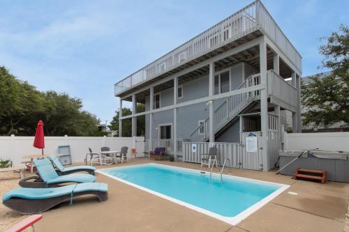 a house with a swimming pool next to a building at Duck Life D4242 - Pool, Rec Room, Sound View in Sanderling