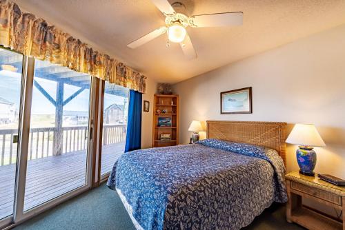 a bedroom with a bed and a balcony at K1108 Dream of Jeanne - Semi-Oceanfront, Rec Room, Private Pool in Nags Head