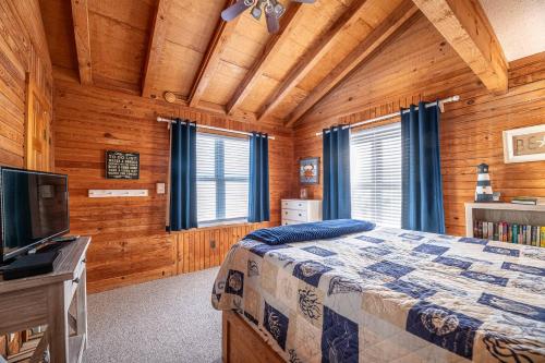 a bedroom with a bed and a flat screen tv at Duck Life D4242 - Pool, Rec Room, Sound View in Sanderling