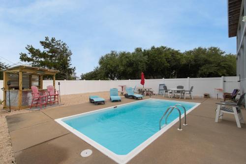 a swimming pool with chairs and a gazebo at Duck Life D4242 - Pool, Rec Room, Sound View in Sanderling