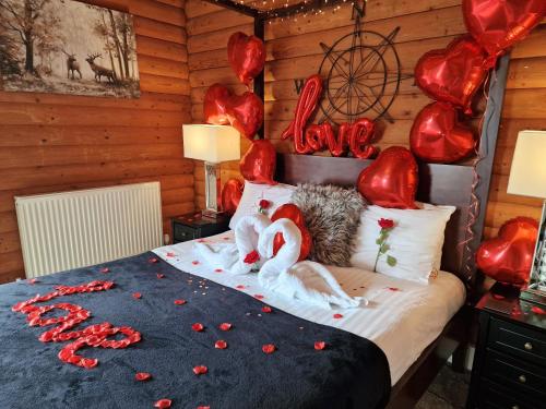 a bedroom with a bed covered in red hearts at Kaoglen-Stags-Hot tub-Cairngorms-Pet Friendly in Balnald