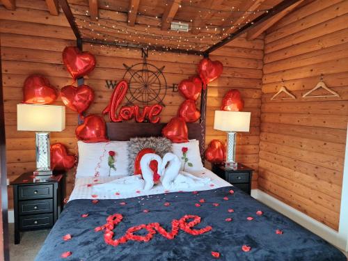 a bedroom with a bed with red hearts on it at Kaoglen-Stags-Hot tub-Cairngorms-Pet Friendly in Balnald