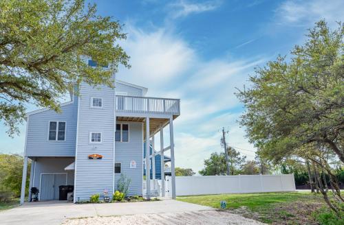 a blue house with a white fence and trees at Duck Life D4242 - Pool, Rec Room, Sound View in Sanderling