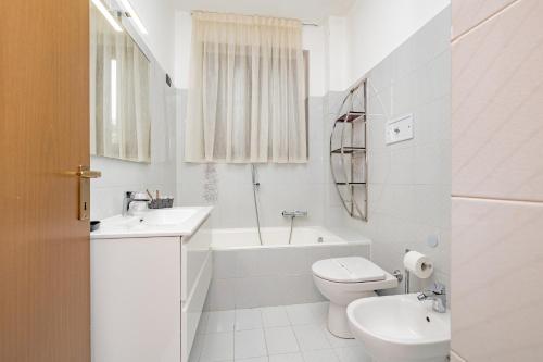a white bathroom with a toilet and a tub and a sink at Fiori del Lario Apt6 110 Mq Fiera Rho Milano Como Malpensa in Cesate