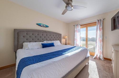 a bedroom with a large bed and a window at K1023 Dream Weaver - Oceanfront, Private Pool, Private Beach Walkway! Pets OK! in Nags Head