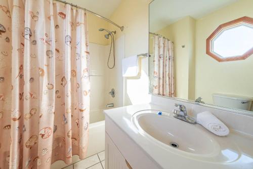 a bathroom with a sink and a shower curtain at K1023 Dream Weaver - Oceanfront, Private Pool, Private Beach Walkway! Pets OK! in Nags Head