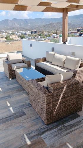 a group of wicker chairs and tables on a patio at Sea And Mountain Views Penthouse Studio With Access To SPA Facilities in Bahçeli