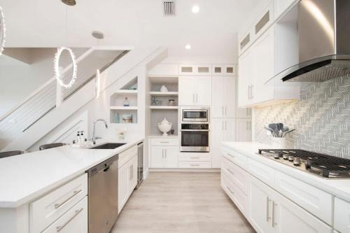a white kitchen with white cabinets and a sink at Mahogany Villa 2-A / 4BR in Omega Gardens