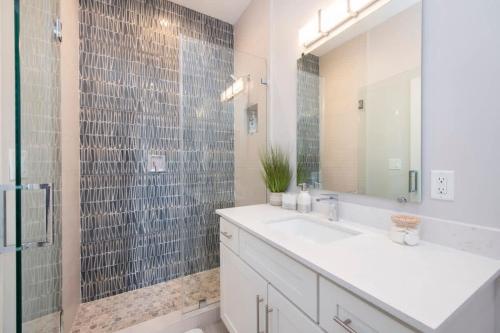 a bathroom with a sink and a shower with a mirror at Mahogany Villa 2-A / 4BR in Omega Gardens